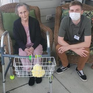 An elderly woman and her caregiver enjoying time together outdoors.