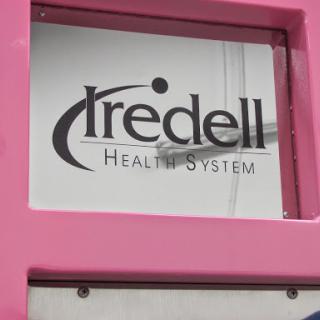 Sign of Iredell Health System displayed on a pink background.
