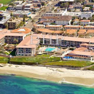 Aerial view of a beachfront resort with surrounding urban area and coastline.