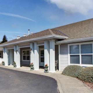 A front view of a building with a driveway and clear blue sky.