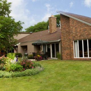 A modern brick house with a well-maintained garden and lawn.