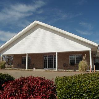 A single-story house with a large covered porch and landscaped front yard.