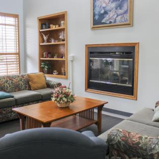 A cozy living room with sofas, a coffee table, and a fireplace.