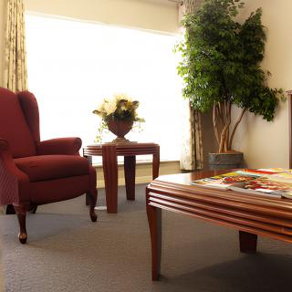 A cozy living room with a comfortable armchair, wooden tables, and elegant decor.