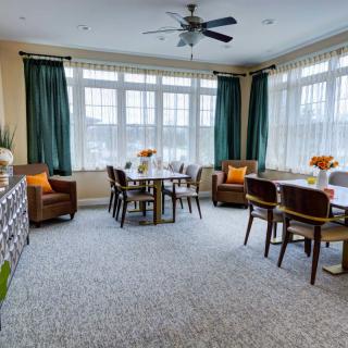 A cozy dining room with large windows, comfortable seating, and elegant decor.