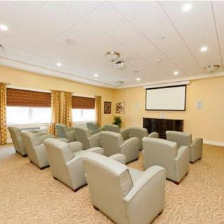 A cozy home theater room with rows of comfortable chairs and a large screen.
