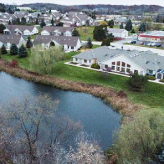 A serene aerial view of a suburban neighborhood beside a tranquil pond.