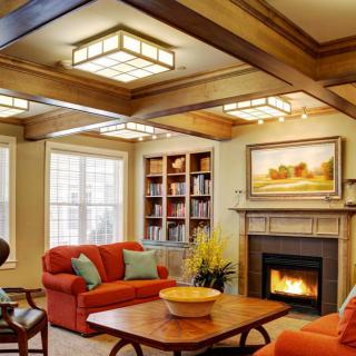 A cozy living room featuring a fireplace, wooden ceiling beams, and comfortable seating.