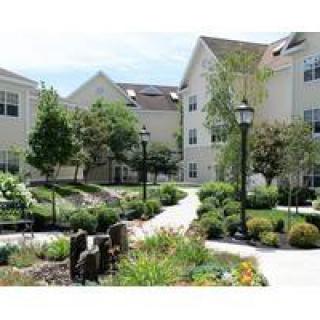A well-landscaped apartment complex featuring a curving pathway and lush greenery.