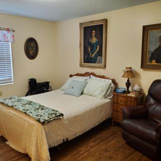 Cozy bedroom with classic decor and paintings on the walls.
