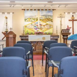 An interior view of a church, showcasing the altar and seating arrangement for attendees.