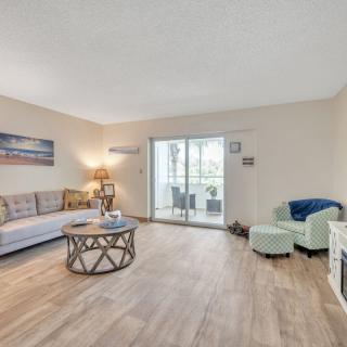 A cozy living room with a sofa, coffee table, and sliding glass door leading to a balcony.