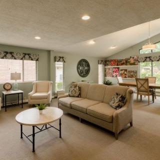 A stylish open-concept living room with neutral tones, featuring a comfortable sofa and adjacent dining area.