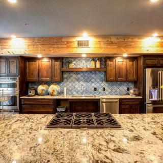 A modern kitchen featuring wood cabinetry and a granite countertop.