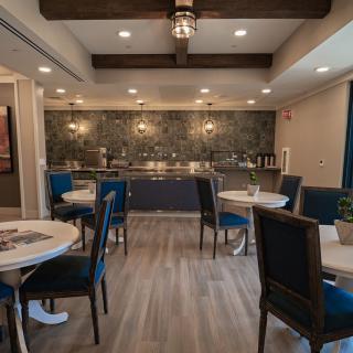 A modern dining area with stylish tables and chairs, featuring warm lighting and decor.