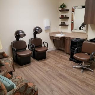 A cozy hair salon setup featuring styling chairs and drying stations.