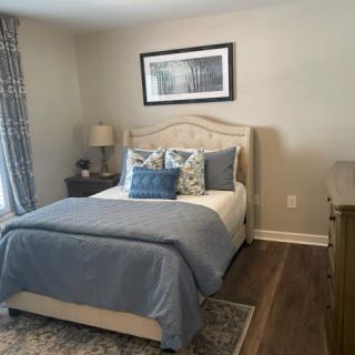 A cozy bedroom with blue bedding and elegant decor.