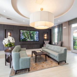 A modern living room with elegant decor, featuring a large chandelier, comfortable sofas, and tasteful wall art.