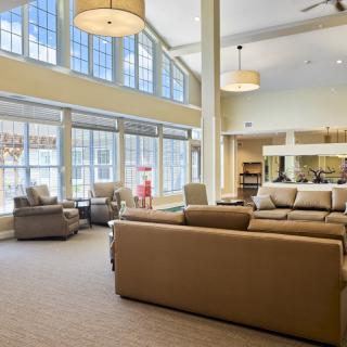 A spacious and modern living room with large windows and comfortable seating.