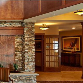 A warm and inviting living area featuring a stone wall, wooden accents, and elegant lighting.