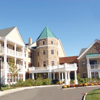 A beautiful residential building with stone and wood architecture, set against a clear blue sky.