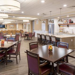 A modern dining area with tables, chairs, and a bar counter.
