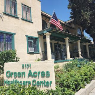 The Green Acres Healthcare Center, showcasing its welcoming facade and American flag.