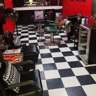 A stylish barbershop interior with checkered flooring and red walls.