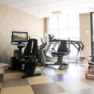 A modern gym with various exercise machines including treadmills and stationary bikes.