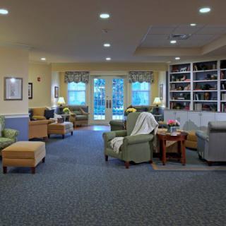 A cozy seating area with comfortable chairs and bookshelves in a well-lit room.