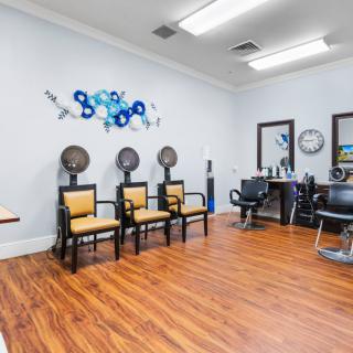 A modern hair salon interior featuring chairs, hair dryers, and stylish decor.