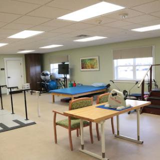 A spacious rehabilitation therapy room equipped with exercise equipment and a bright, inviting atmosphere.