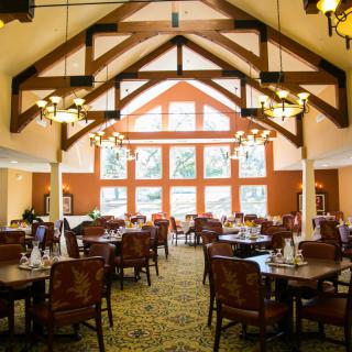 A spacious dining area with elegant lighting and large windows.