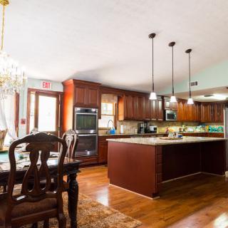 Spacious kitchen and dining area with wood flooring and elegant pendant lighting.