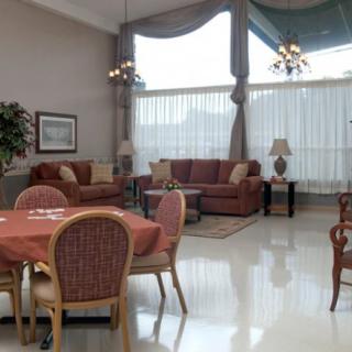 A spacious and elegantly furnished living room with large windows and comfortable seating.