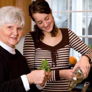 Two women enjoying cooking together in the kitchen.