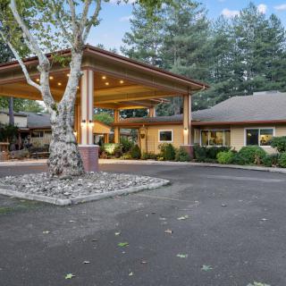 A welcoming entrance with a covered walkway surrounded by lush greenery.