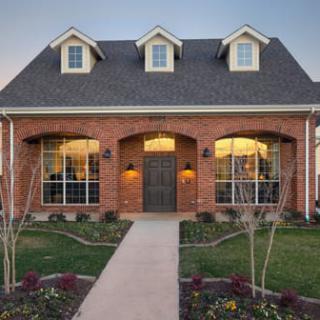 A beautiful brick house with well-maintained landscaping and a welcoming front porch.