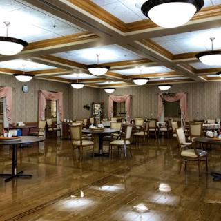 A spacious and elegantly designed dining room featuring wooden floors, well-arranged tables, and modern lighting fixtures.