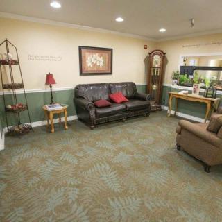 A cozy living room with a sofa, grandfather clock, and decorative elements.