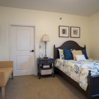A cozy bedroom with a bed, nightstand, and decorative elements.