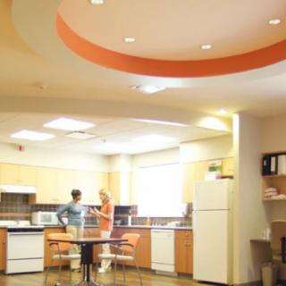A modern kitchen interior with two people and various appliances.