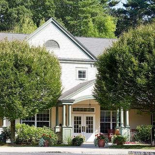 A charming house surrounded by lush trees with an inviting entrance.
