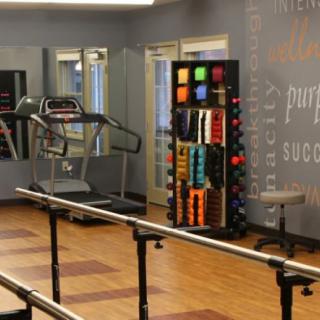 A well-equipped gym with a treadmill, weights, and exercise equipment.