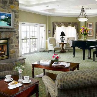 A cozy living room with a fireplace and grand piano.