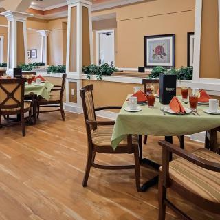 A well-decorated dining area with neatly arranged tables and chairs, set for guests.
