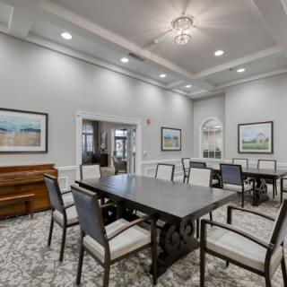 Elegant dining room with a large table, surrounded by chairs and decorated with artwork.