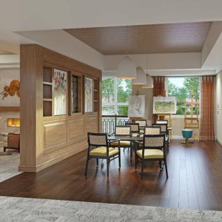 A modern dining area with wood flooring and large windows allowing ample natural light.