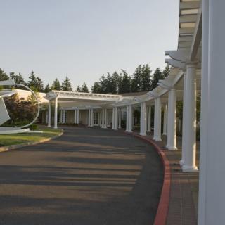 A curved outdoor walkway with columns under a clear sky.