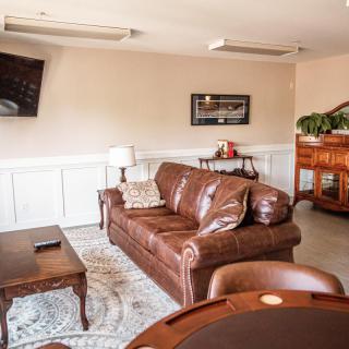 A cozy living room with a leather sofa, coffee table, wall-mounted TV, and tasteful decor.